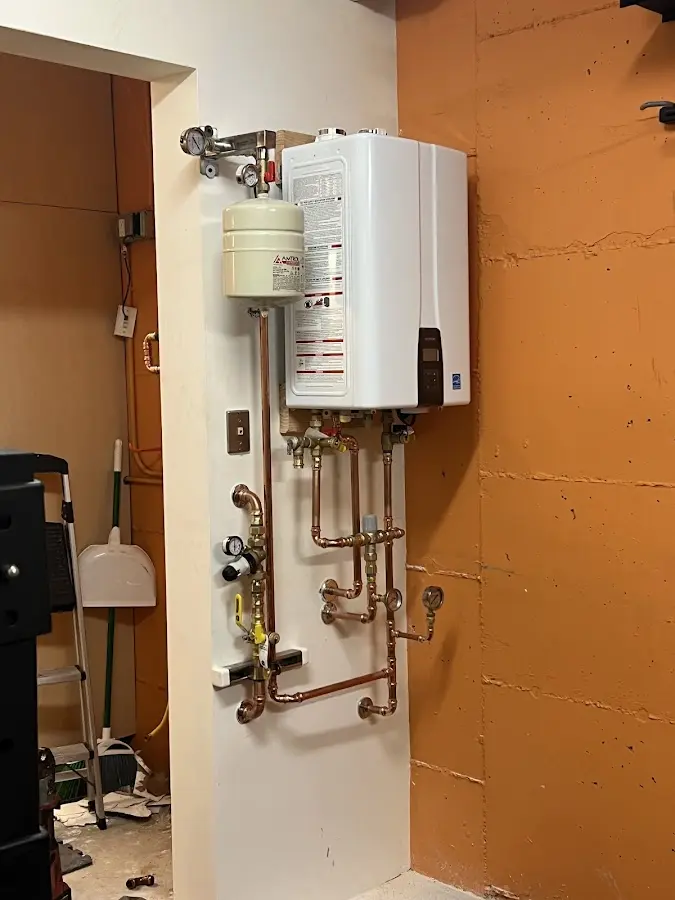 Plumbing technician inspecting water heater connections in Zionsville